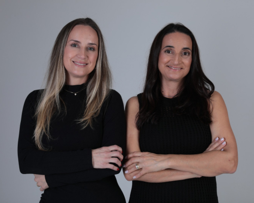 Duas profissionais da ZKF Contabilidade sorrindo em ambiente corporativo